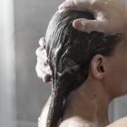 young-woman-applying-anti-dandruff-product